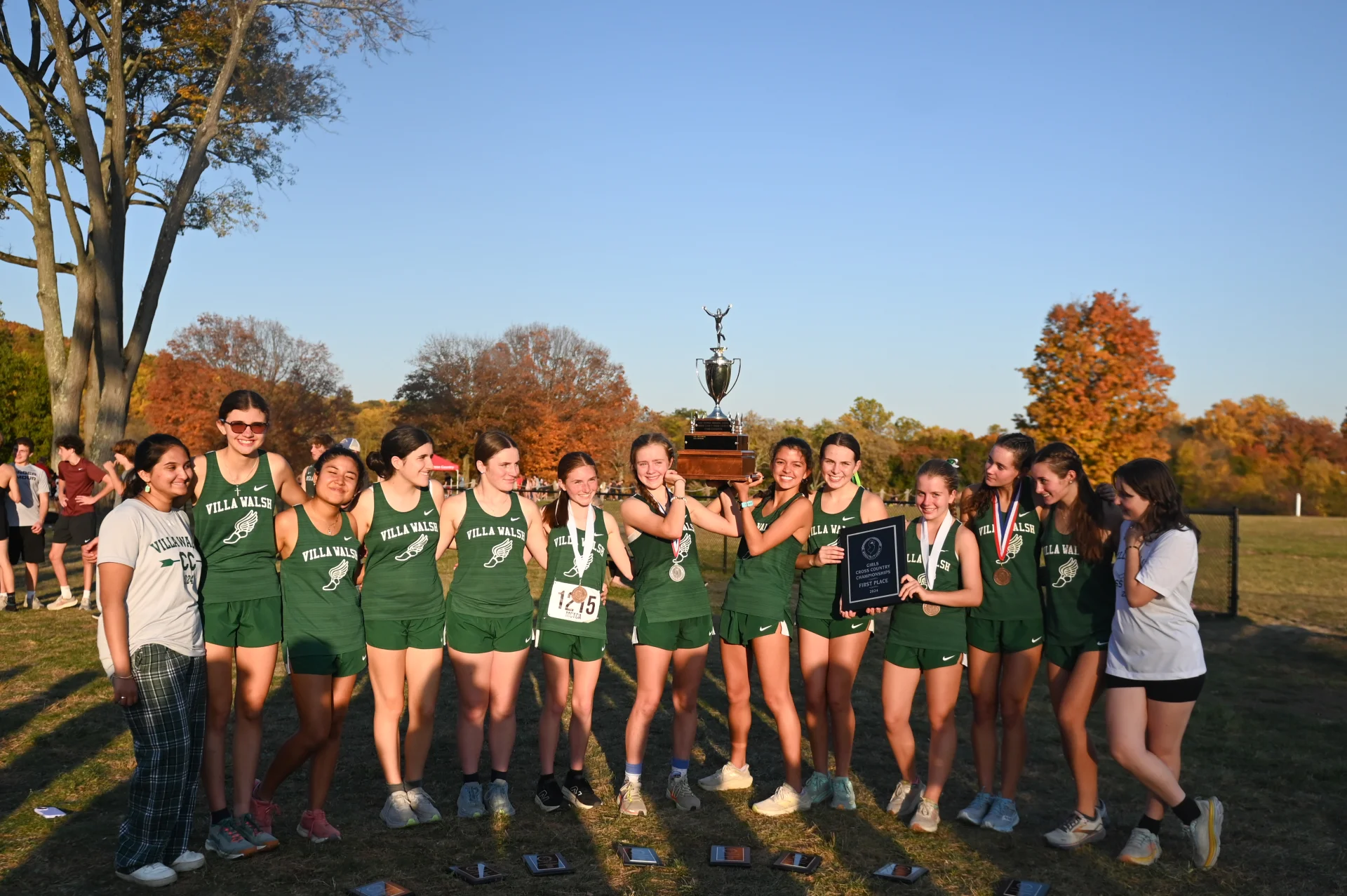 2024 cross country team holding a trophy